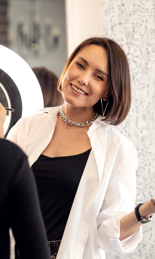 make-up artist applies the model's makeup in the beauty salon before the holiday